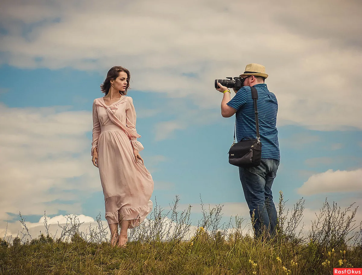 Un fotograf fotografiind o femeie pe un câmp